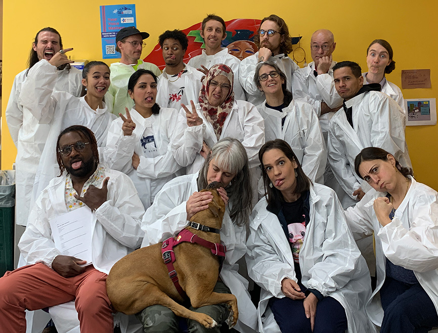 Boulder Prep staff grouped together making funny faces with Story, the school's therapy dog.